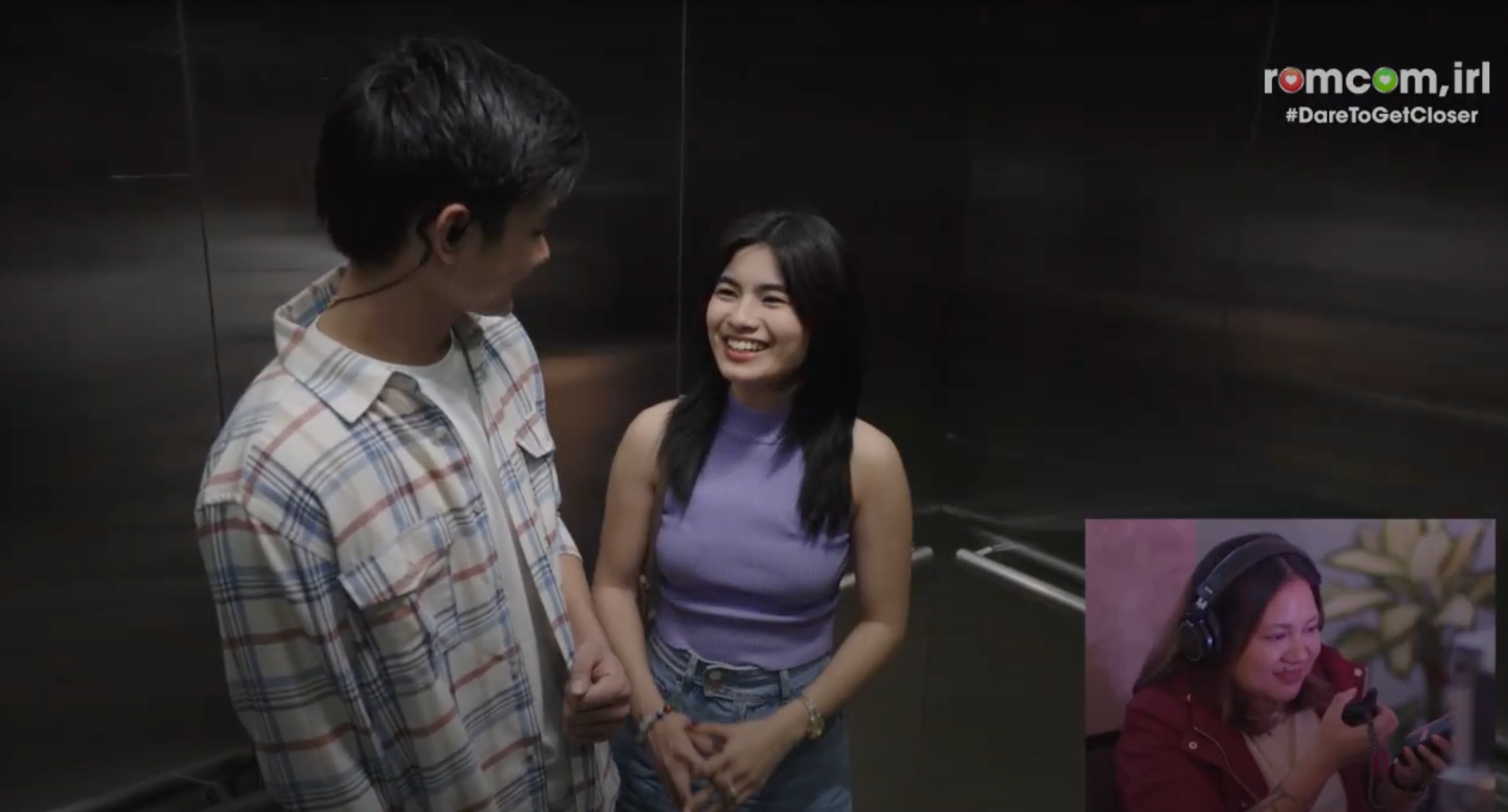 A man and a woman smiling at each other in an elevator.