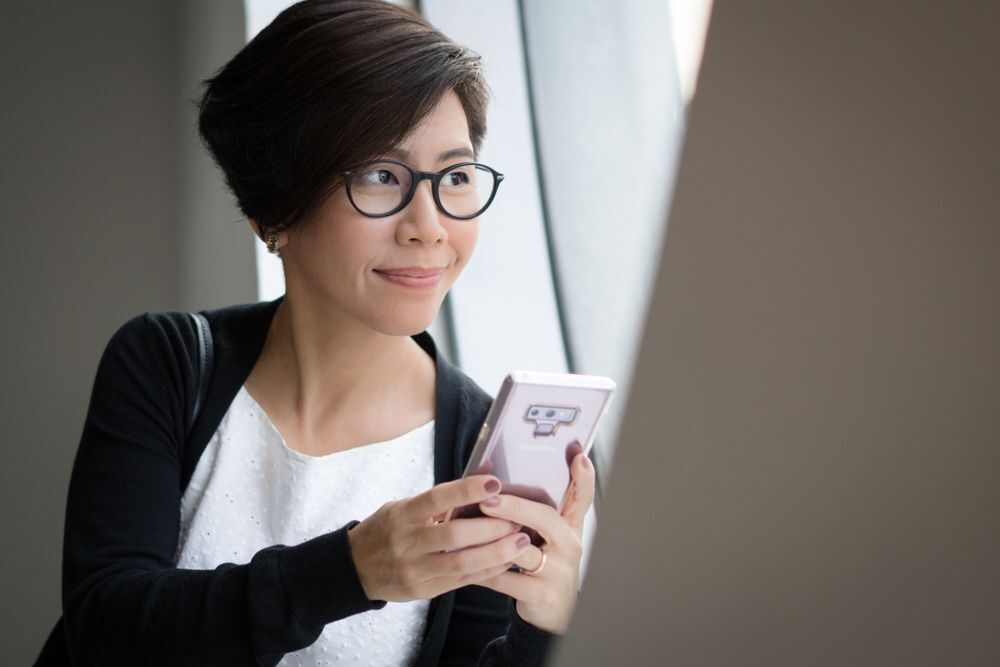 An Asian woman with short hair on the phone.