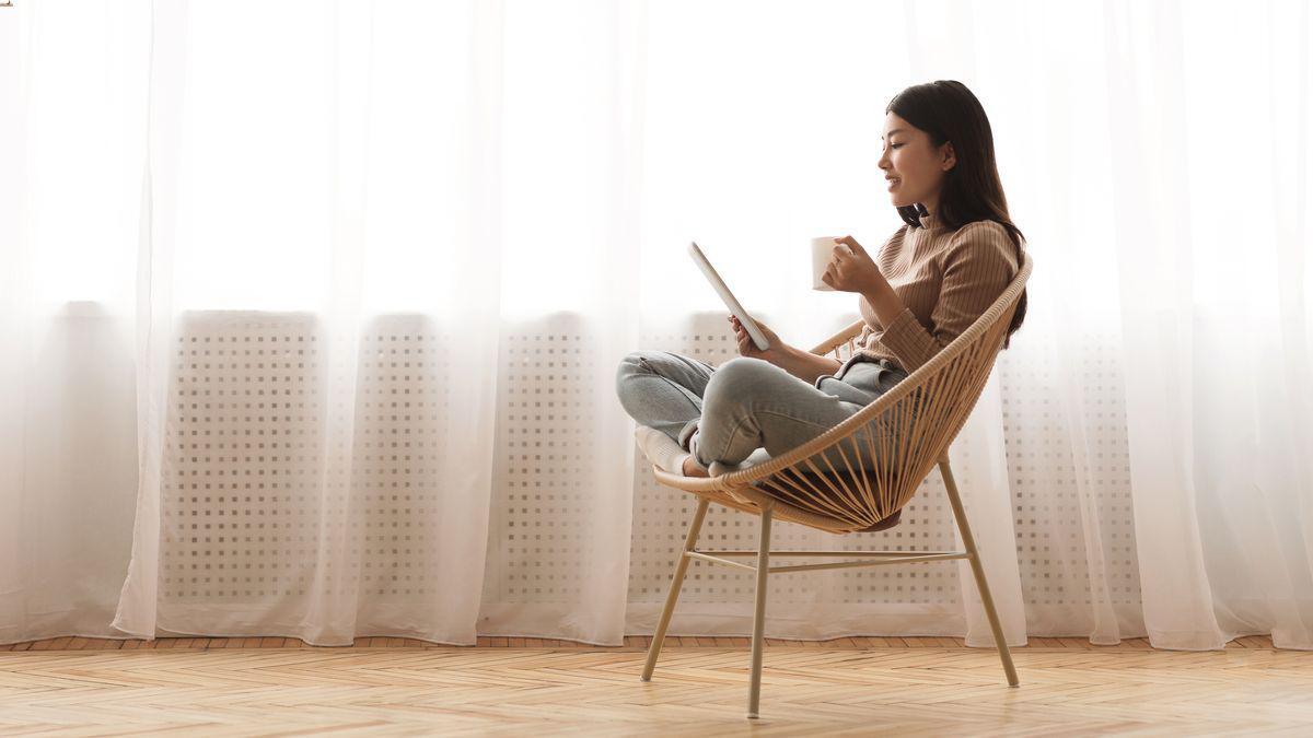 Asian woman sitting on a wicker chair 