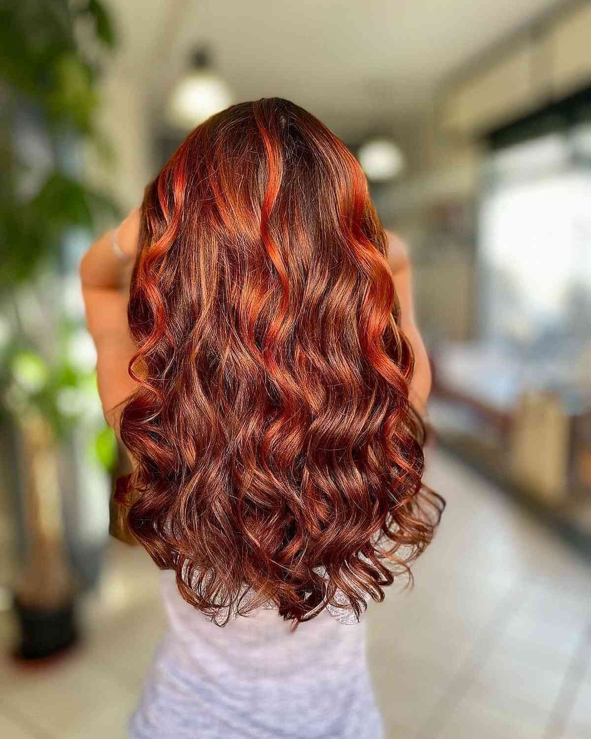 Backside of a woman running her hands through her wavy red hair