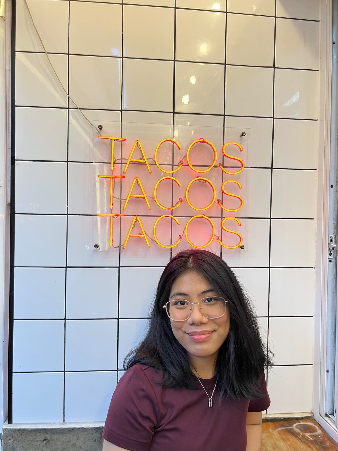 Smiling Asian woman with black hair at a restaurant.