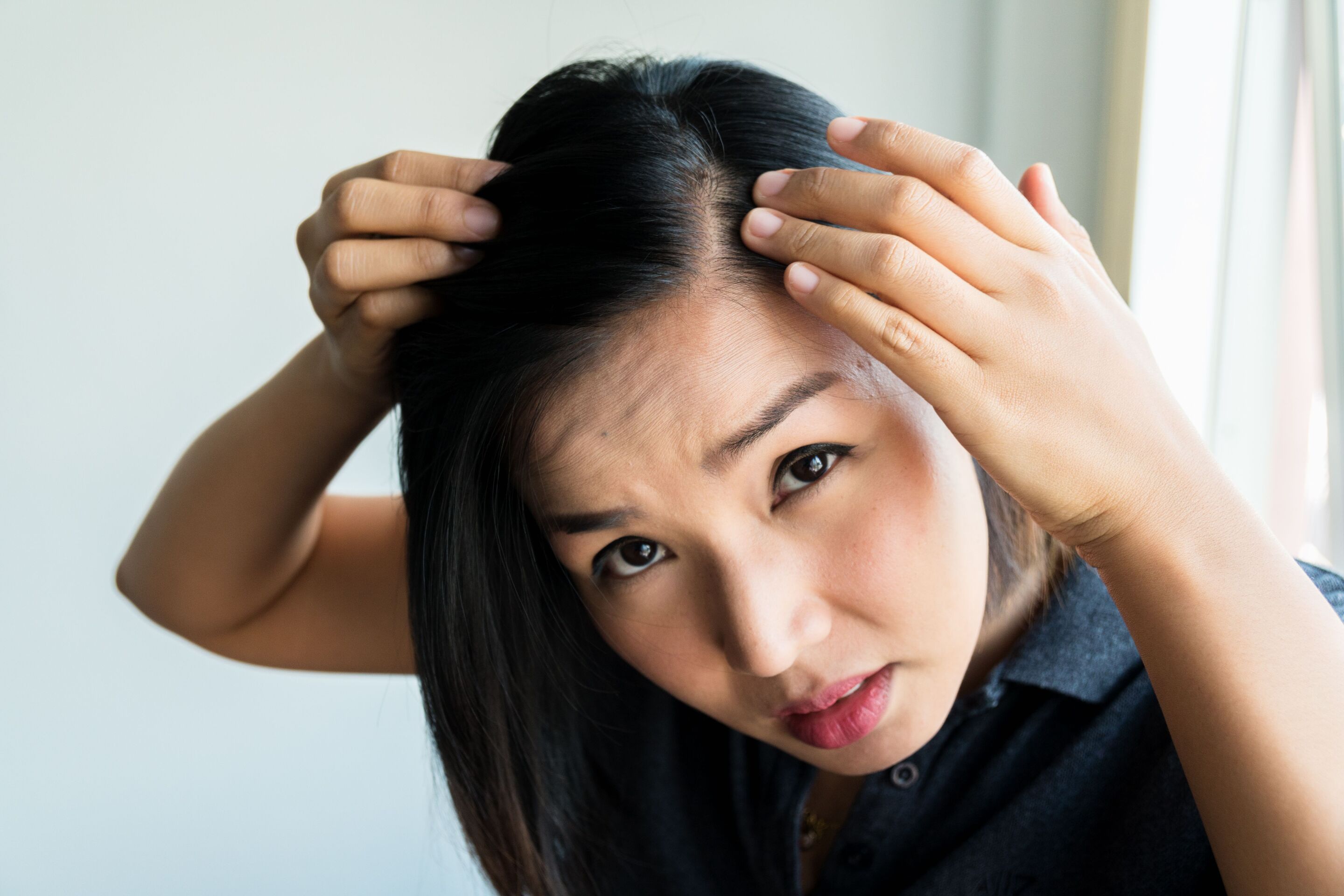 Woman looking at her scalp.