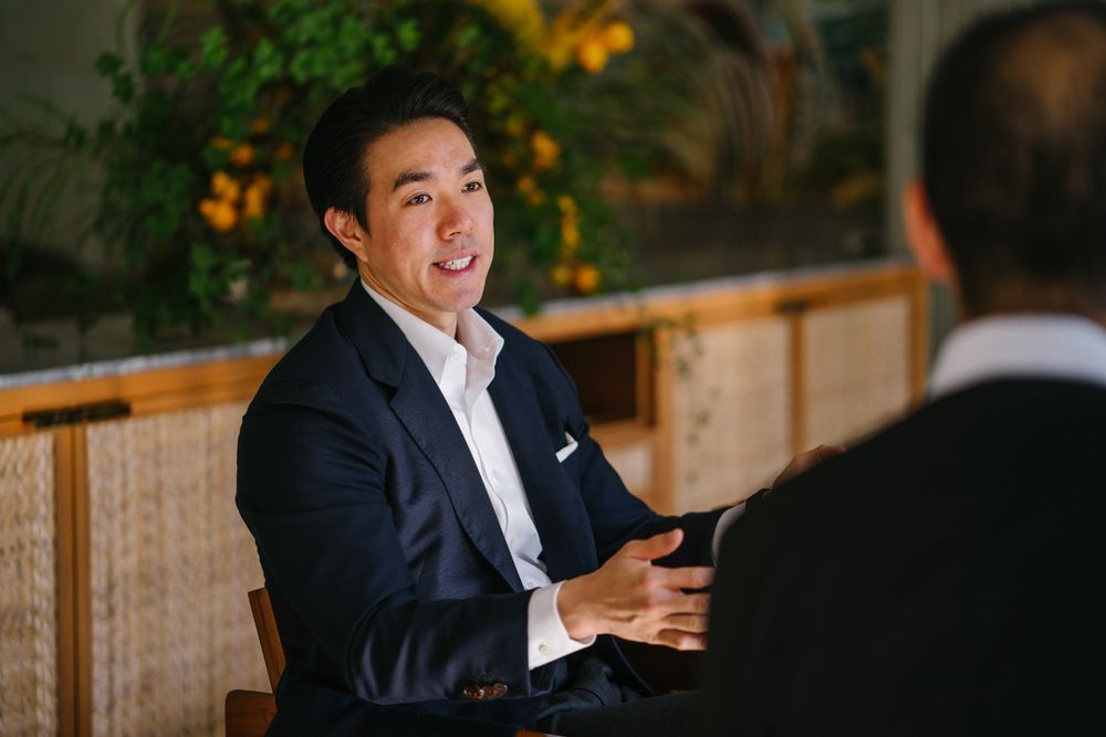 A handsome young man talking to others.