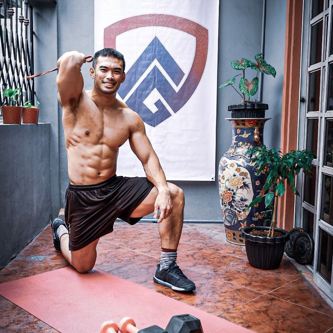CrossFit Champion Justin Hernandez posing with his equipment at home