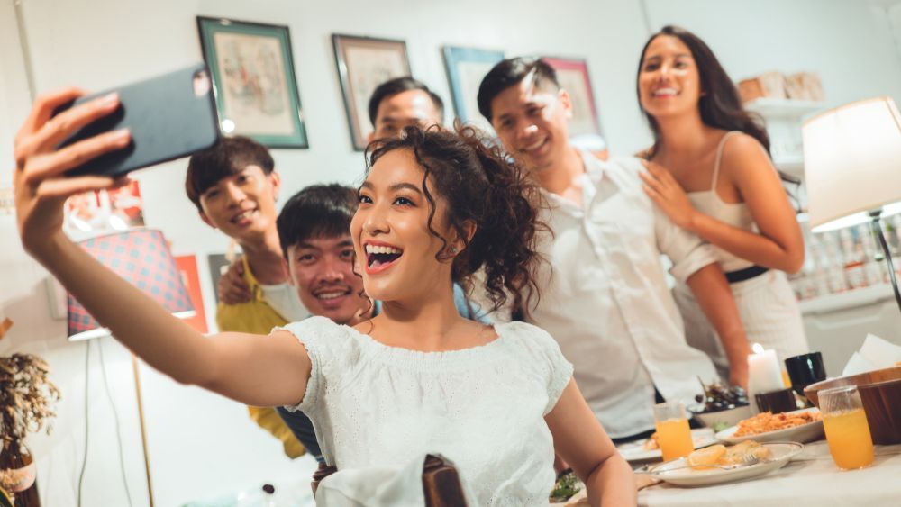 A group of friends dress in white outfits and taking a selfie