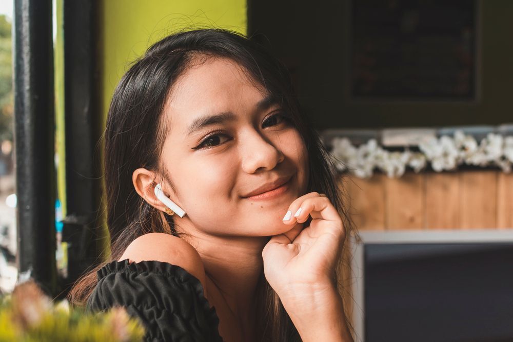 A Filipina woman in black top smiling.