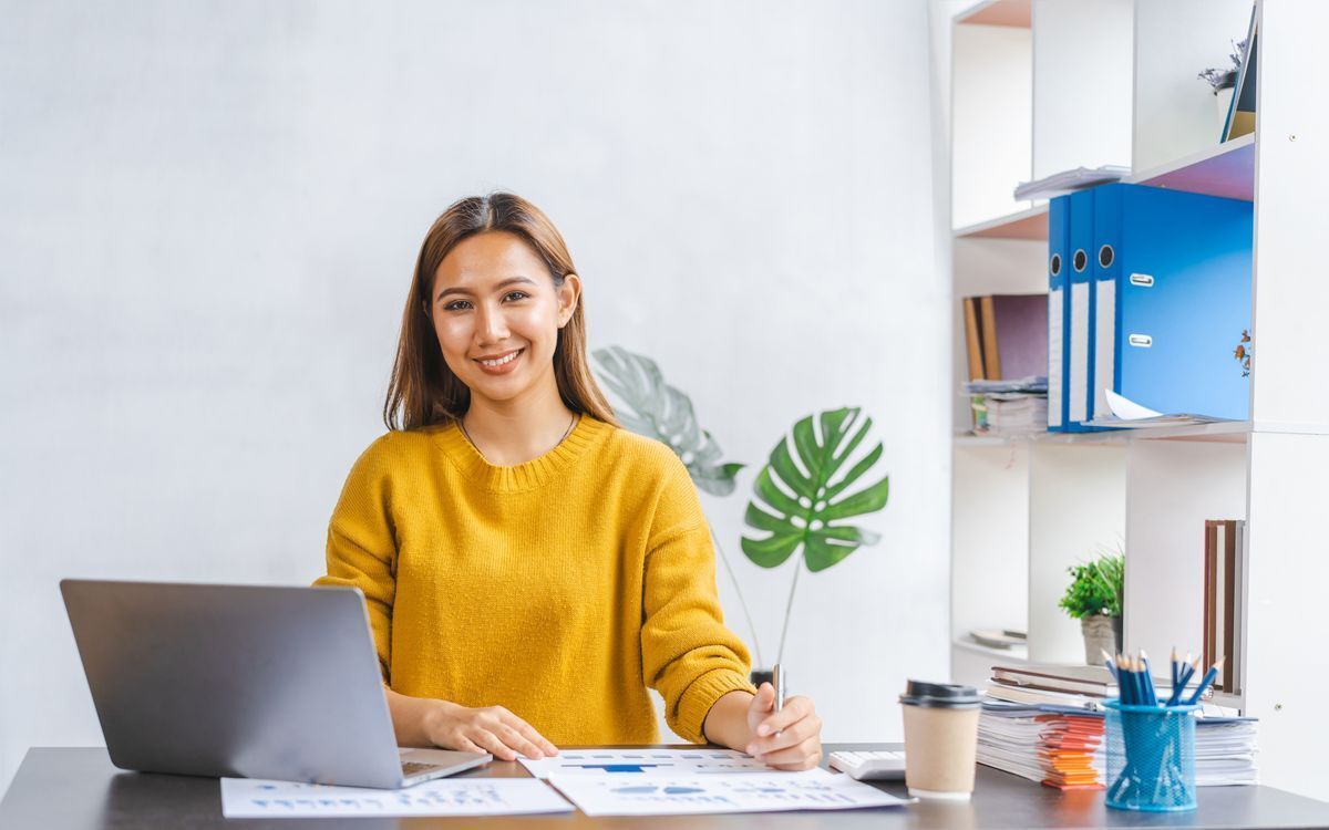 Asian woman with a golden brown skin tone wearing a yellow sweater.