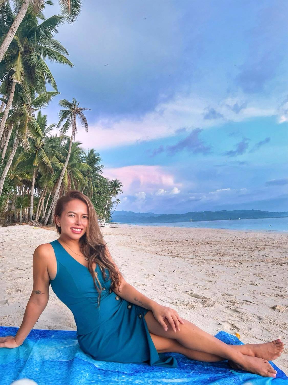 Woman sitting on the sand on the beach.