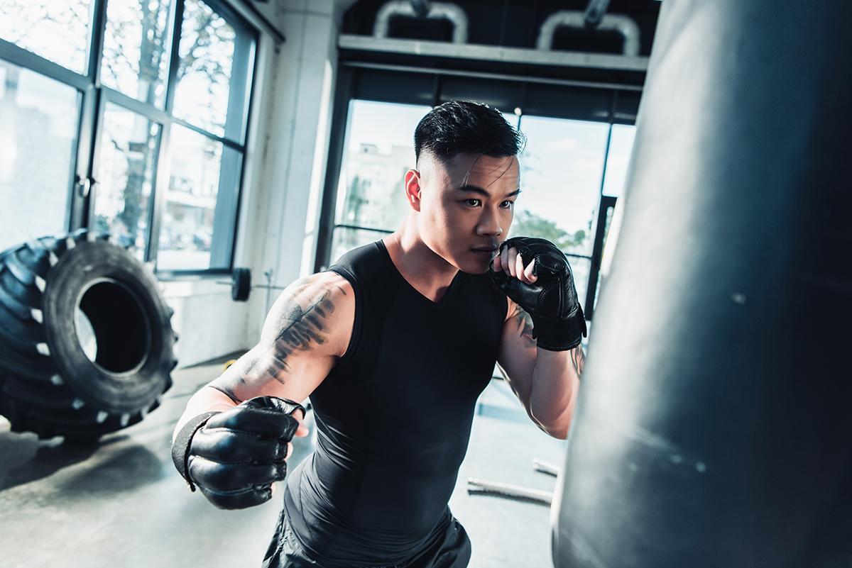 Young man wearing boxing gloves in the gym 