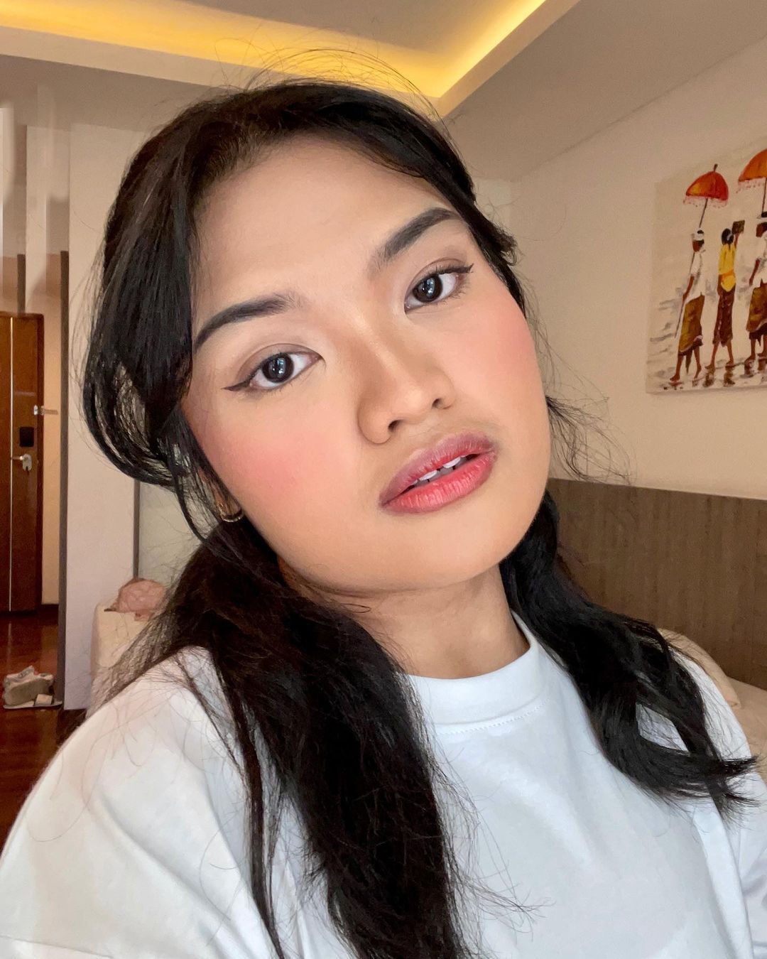 A selfie of Asian woman with full makeup and long hair. 