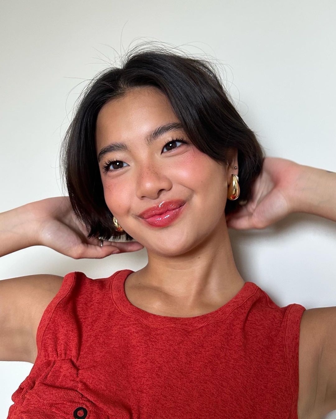 Woman wearing red top and strawberry makeup.