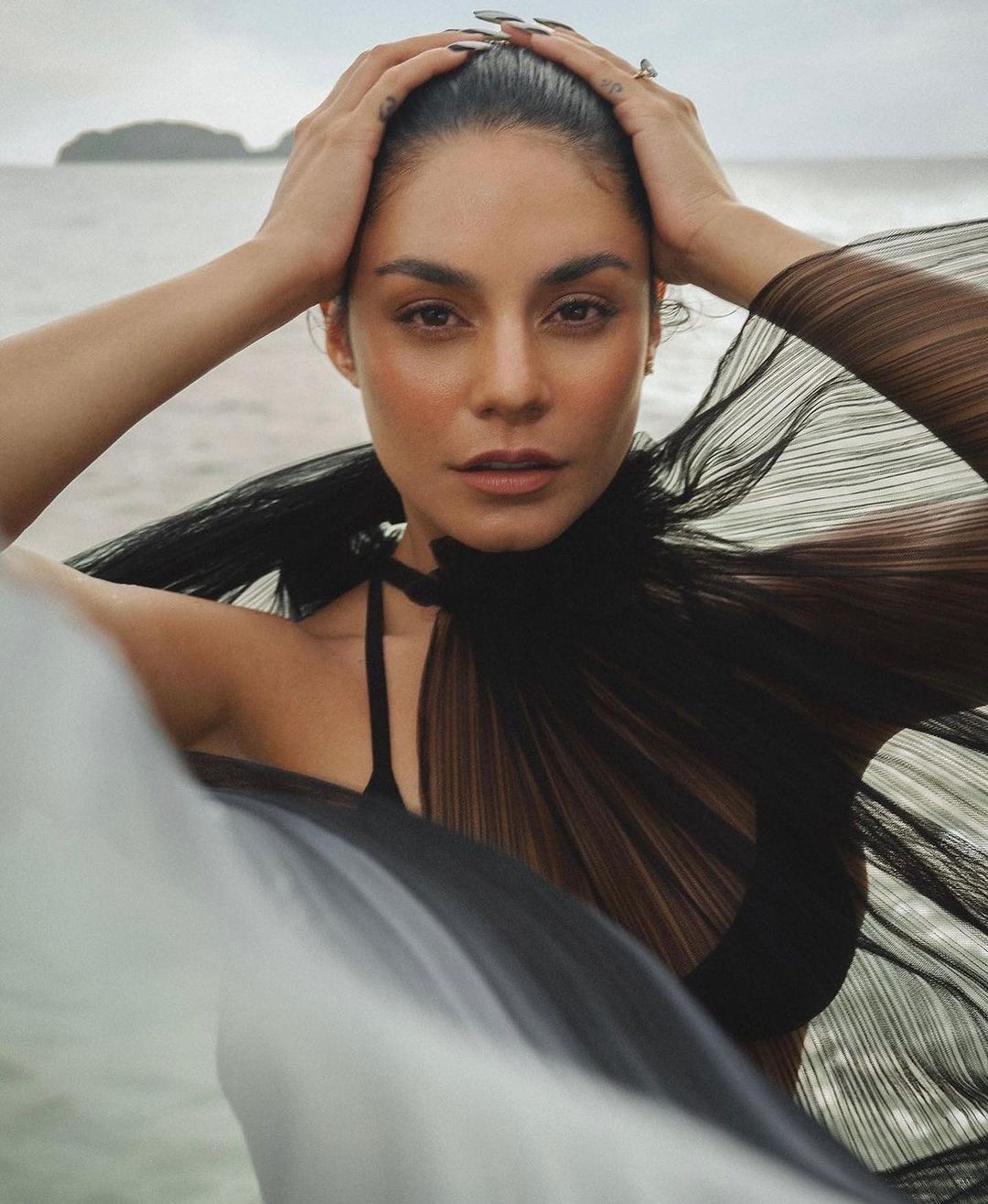 A portrait of Vanessa Hudgens wearing brown dress and sleek bun.
