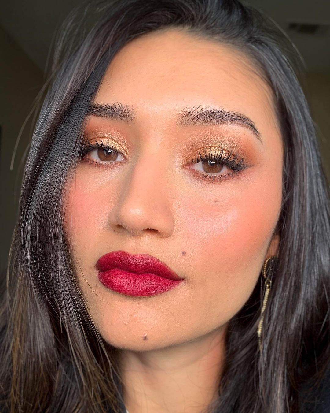 A portrait of woman with red lips and long lashes.