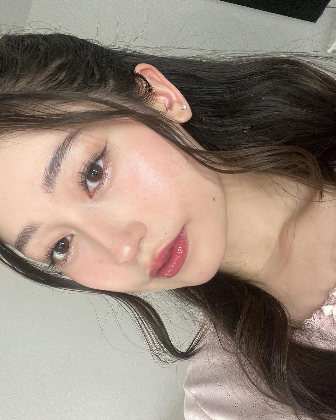 A portrait of woman wearing pink lip gloss.