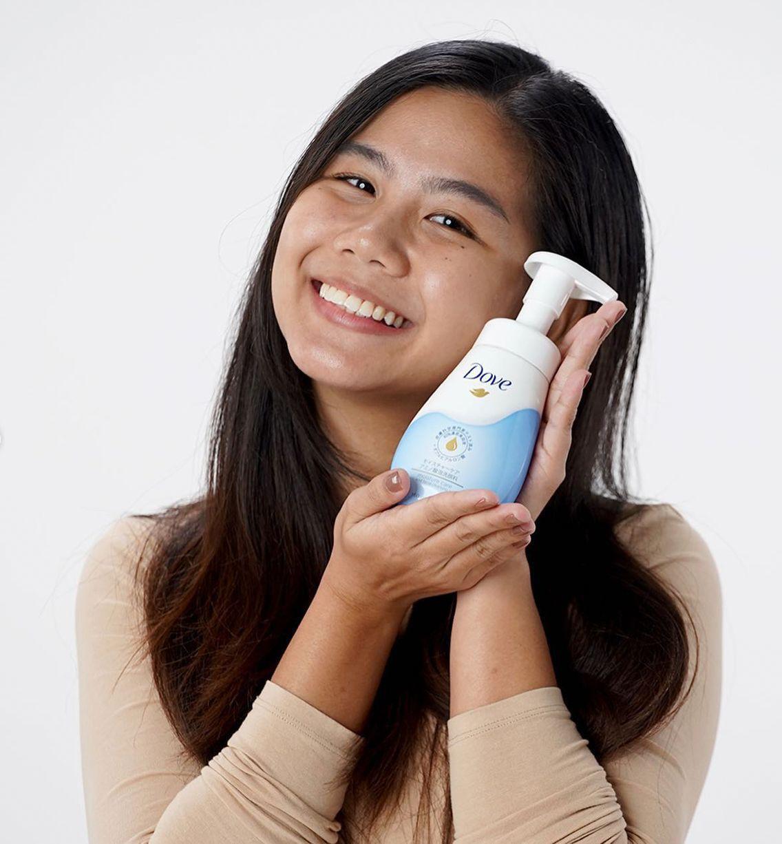 Filipina holding a bottle of facial cleanser