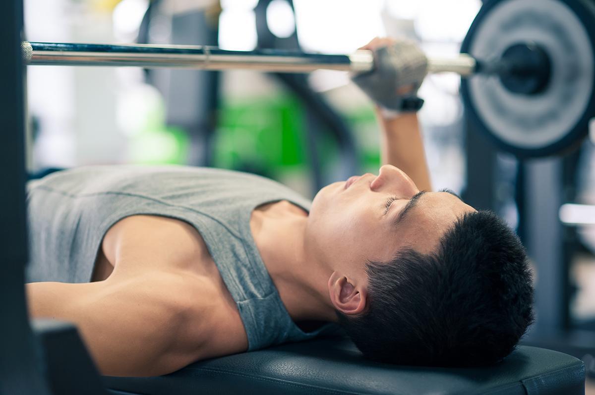 Asian man doing weights at the gym