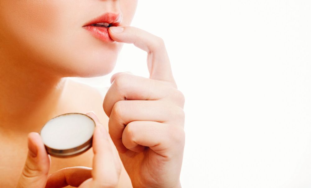 A woman applying lip balm