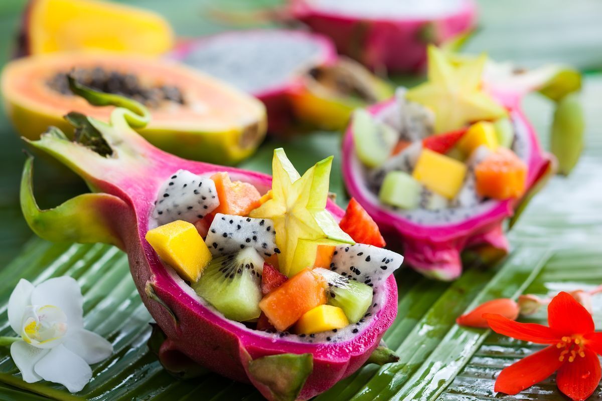 Halved and hollowed dragon fruit with a colorful fruit salad inside. 
