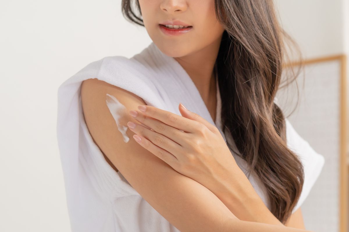 A woman applying skincare on her arm.