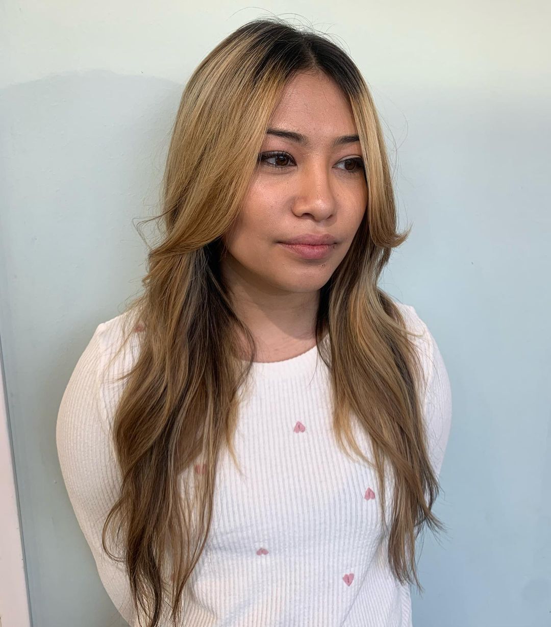 Woman with long, blonde hair and face-framing layers.