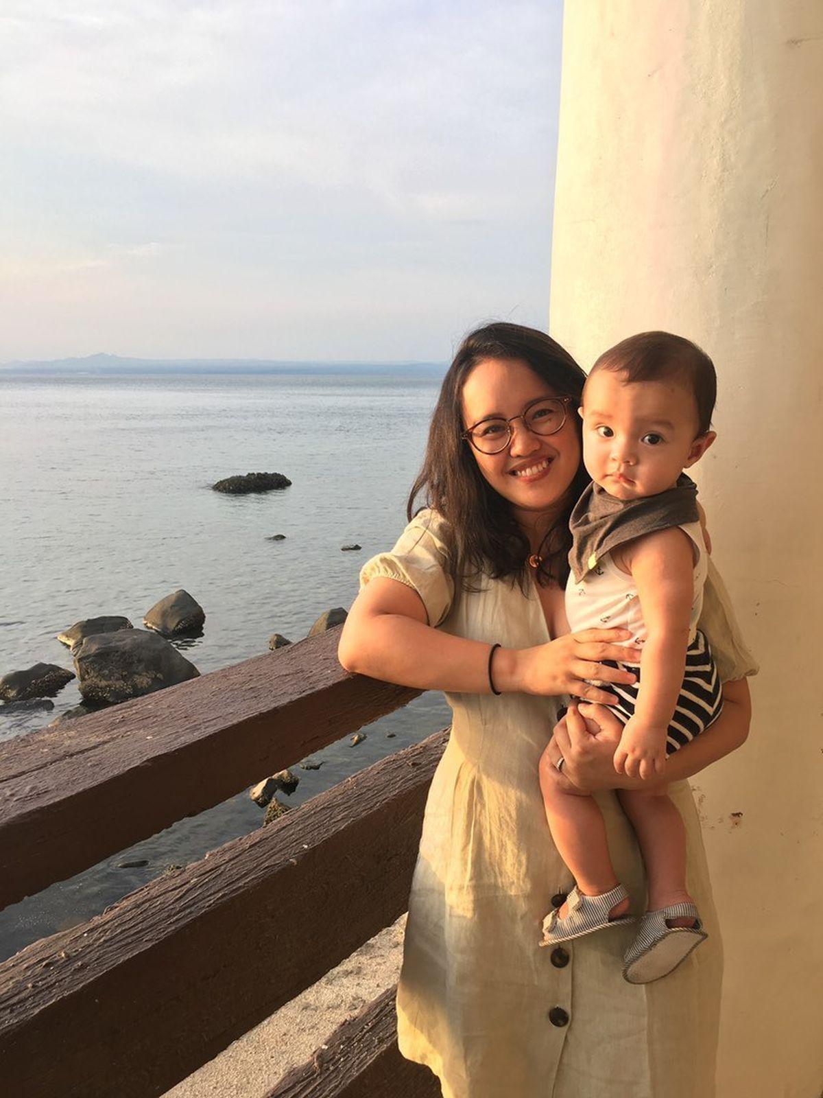 Asian woman carrying baby on dock 