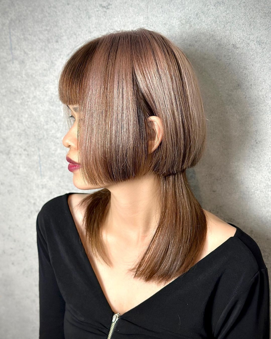 Woman with ash brown jellyfish haircut. 