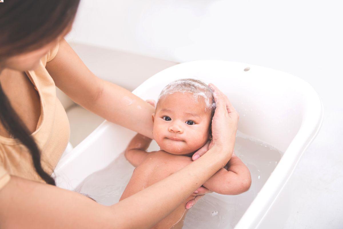 Asian baby bathing in tub 