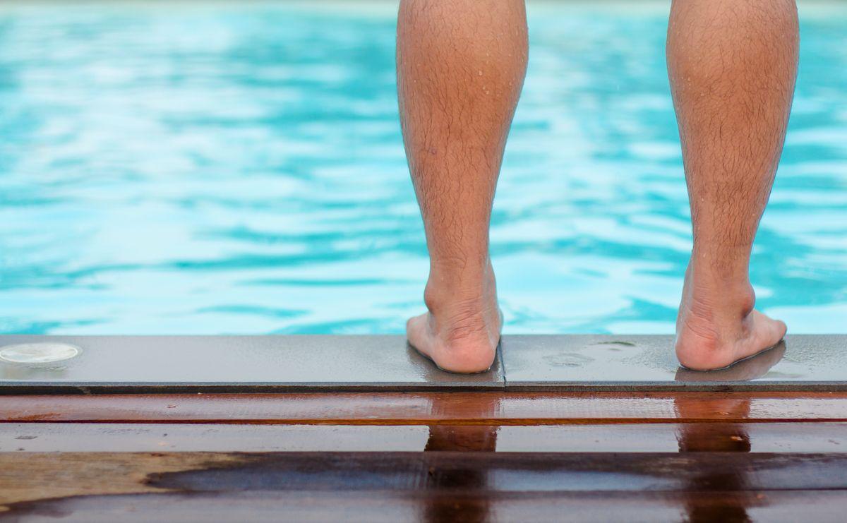 Man barefoot by a swimming pool