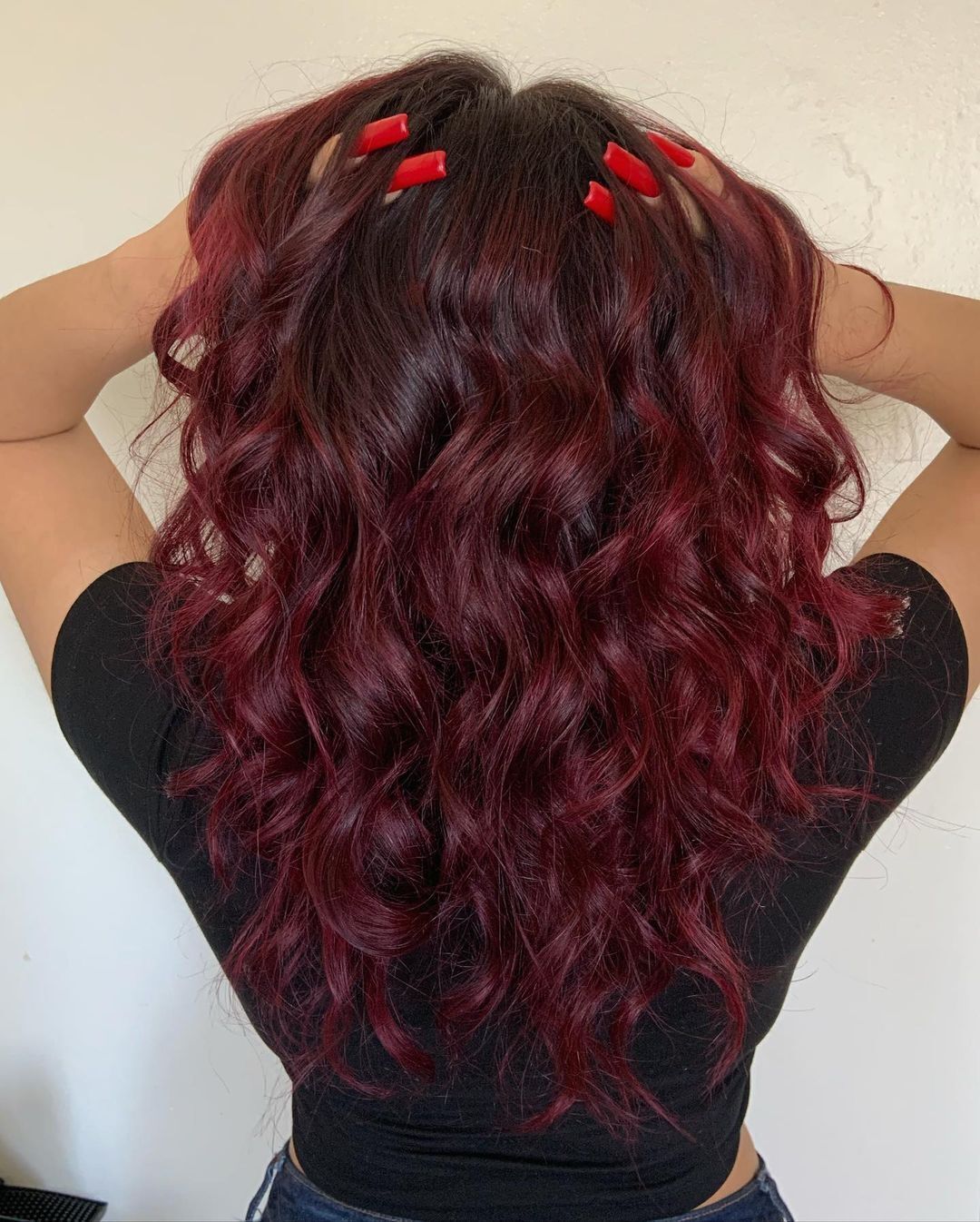 Woman with red nails and red hair highlights.