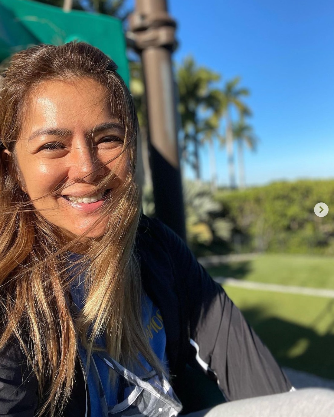 Smiling Asian woman with bleached blonde hair.