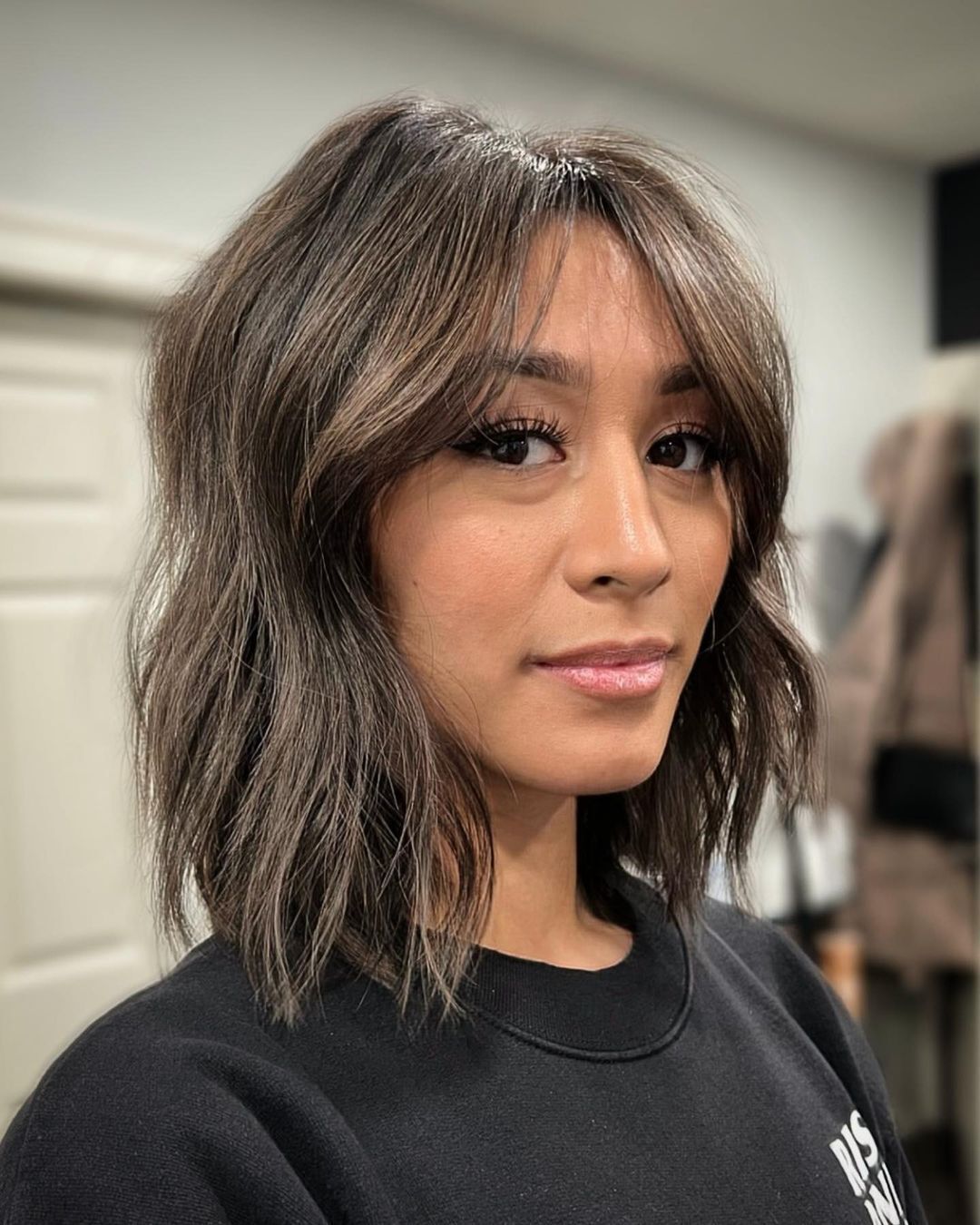 Woman with long bob and ash brown highlights.