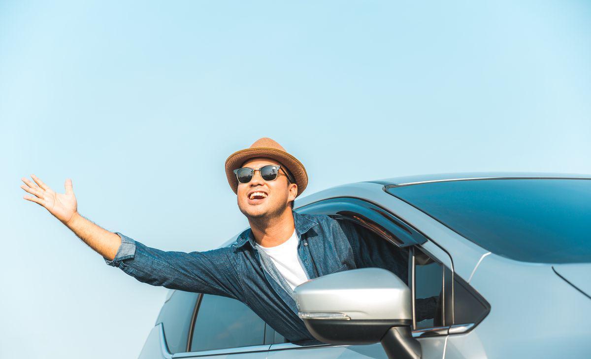 Asian man sticking head out of car 