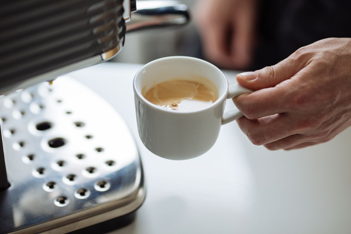 A hand holding a coffee cup