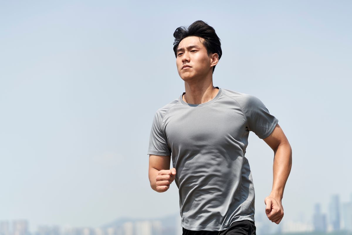 Asian man running outdoors