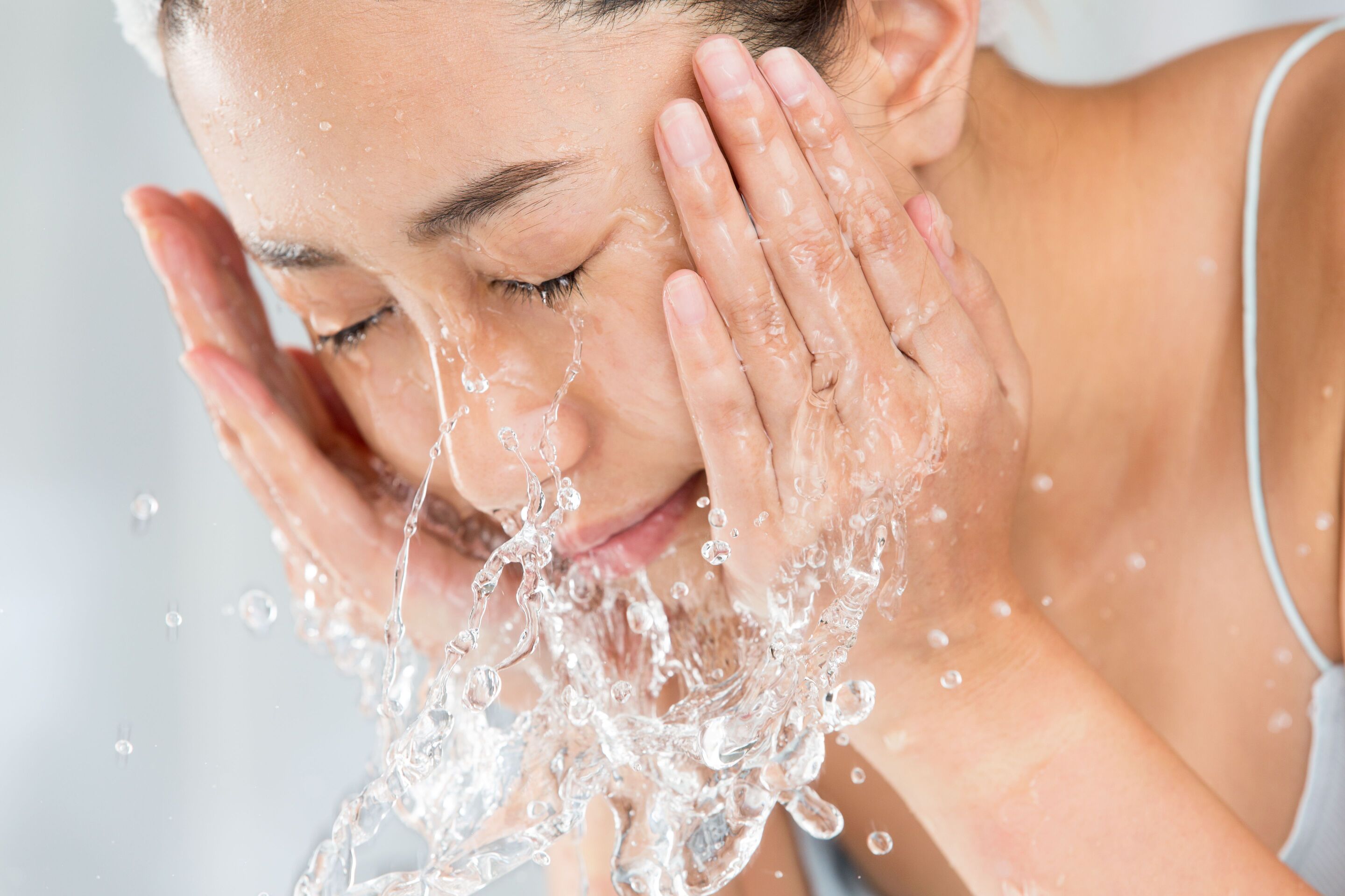 Young woman washing her face