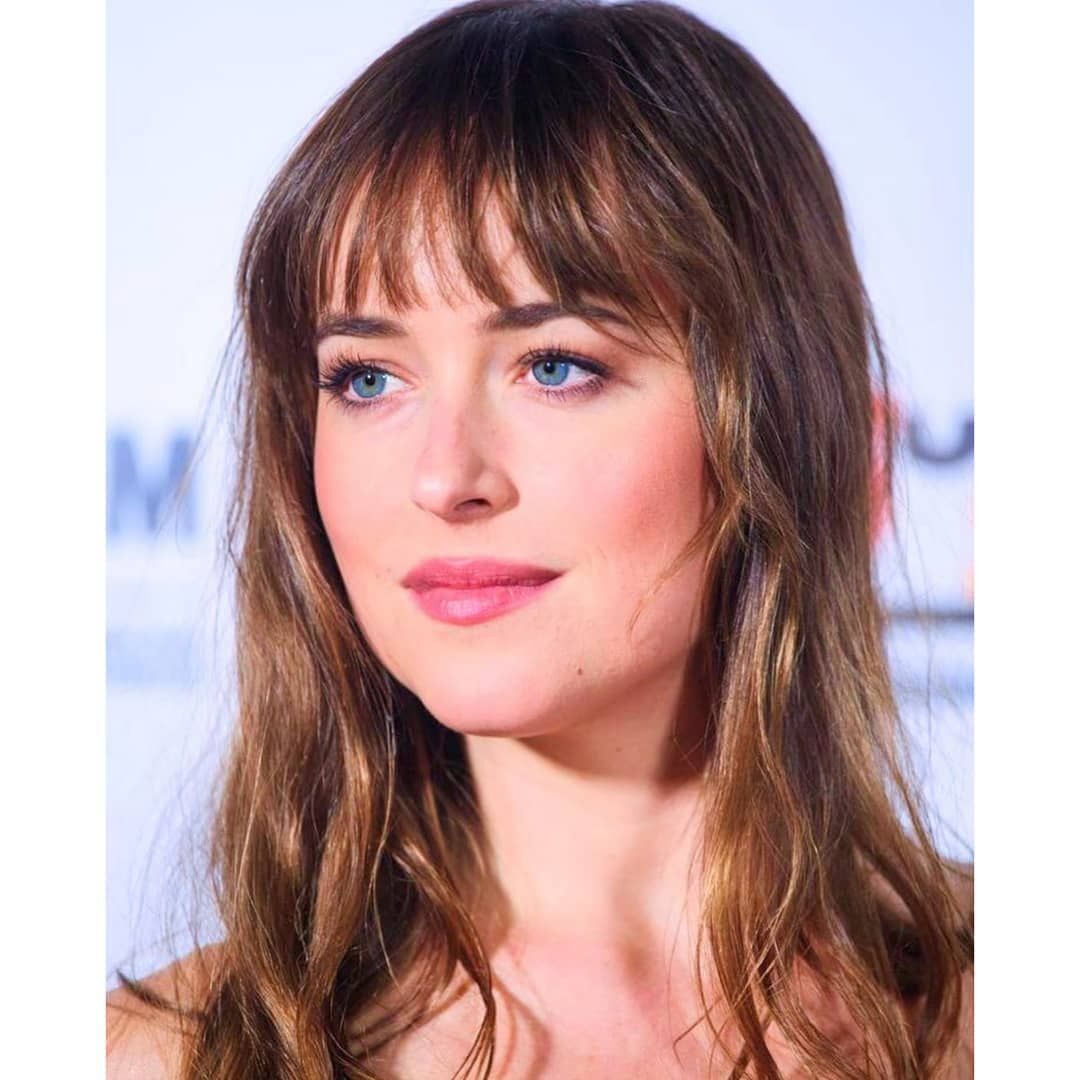 Closeup of Dakota Johnson with long hair and bangs