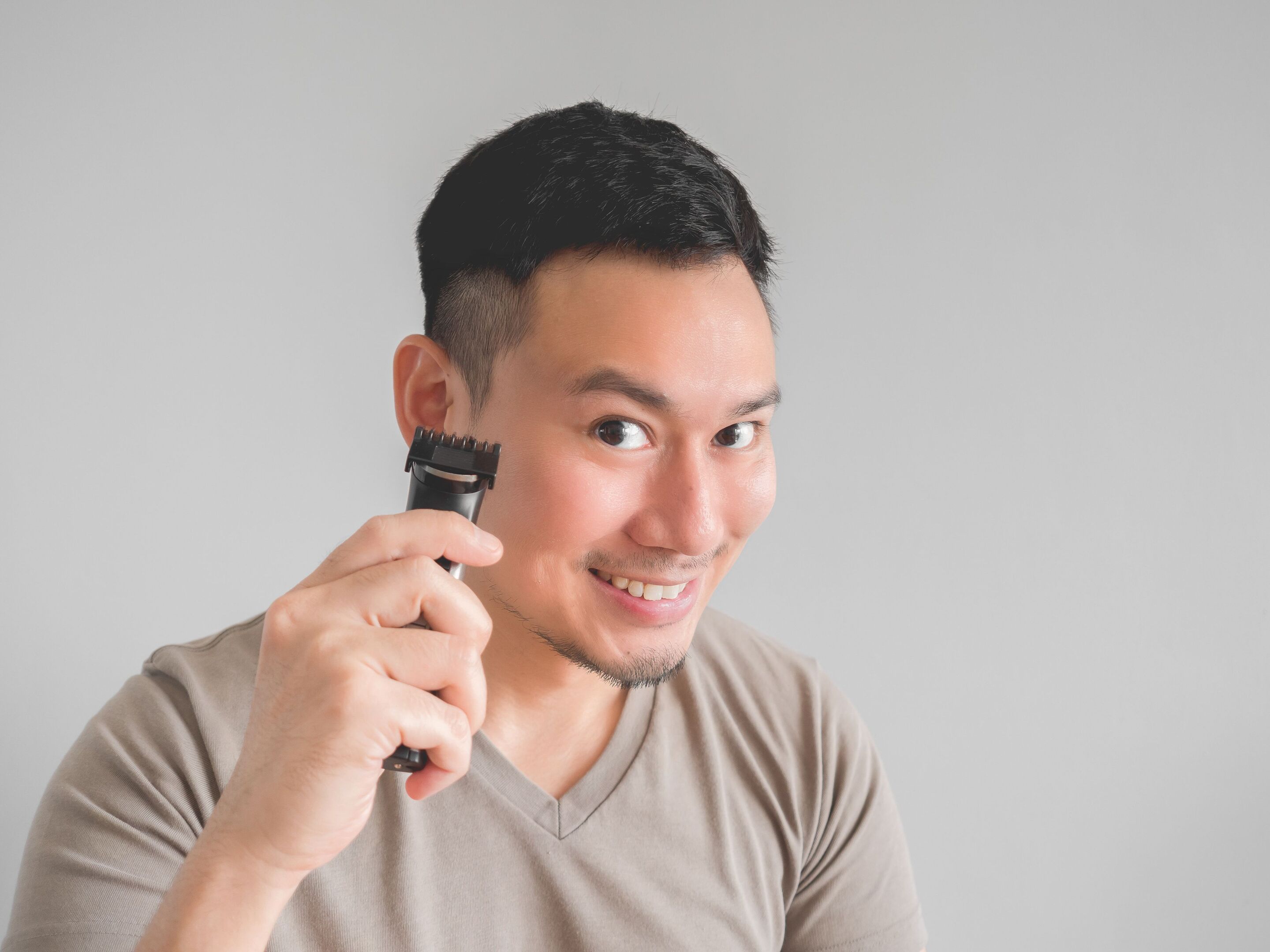 Asian man trimming sideburns