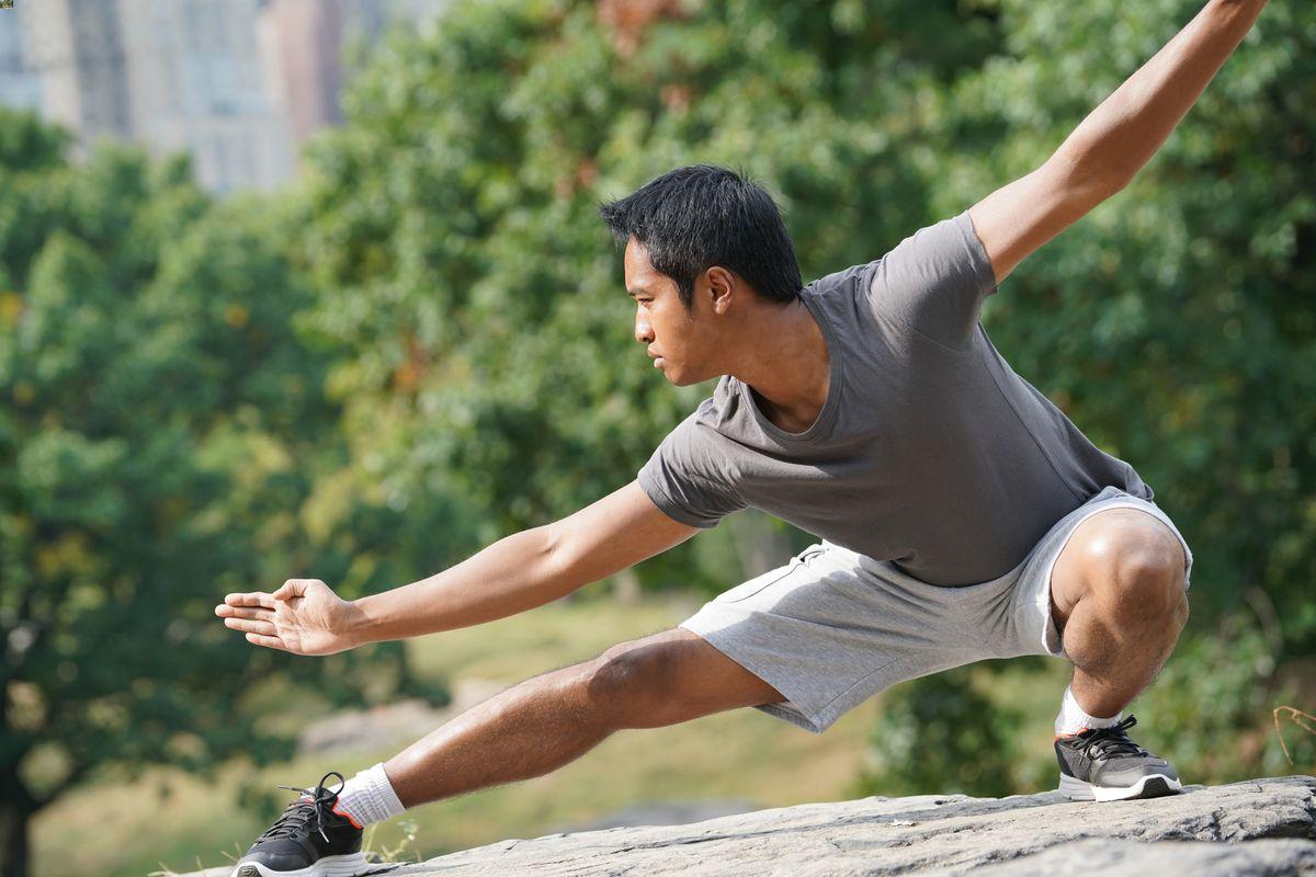 Asian man practicing tai chi outdoors 