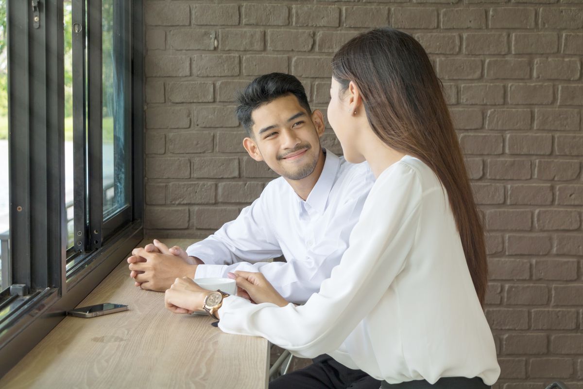 Asian man on a coffee date with a woman.