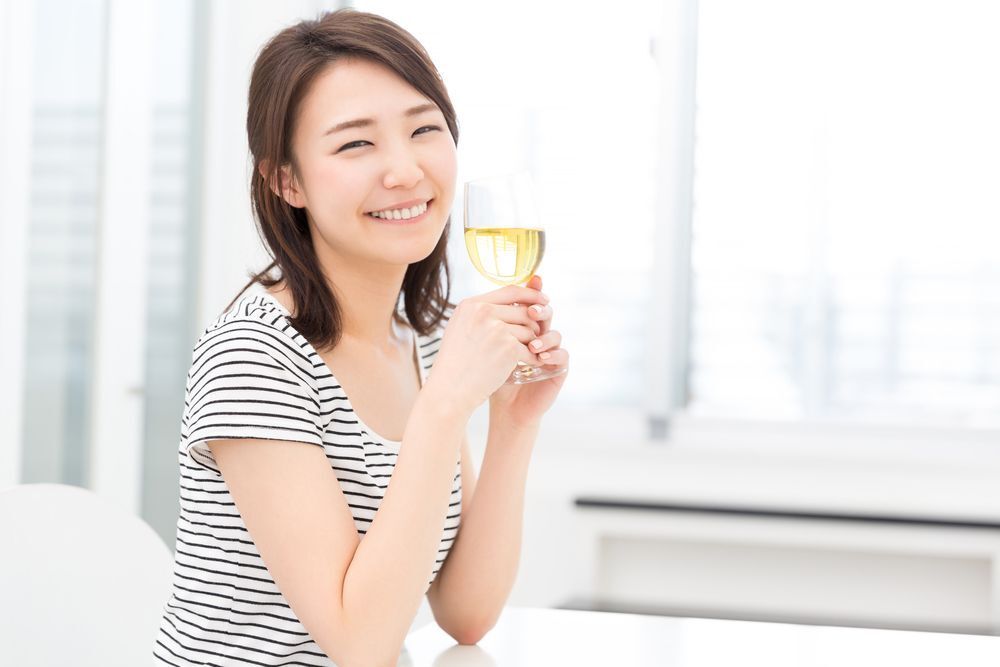A woman drinking white wine 