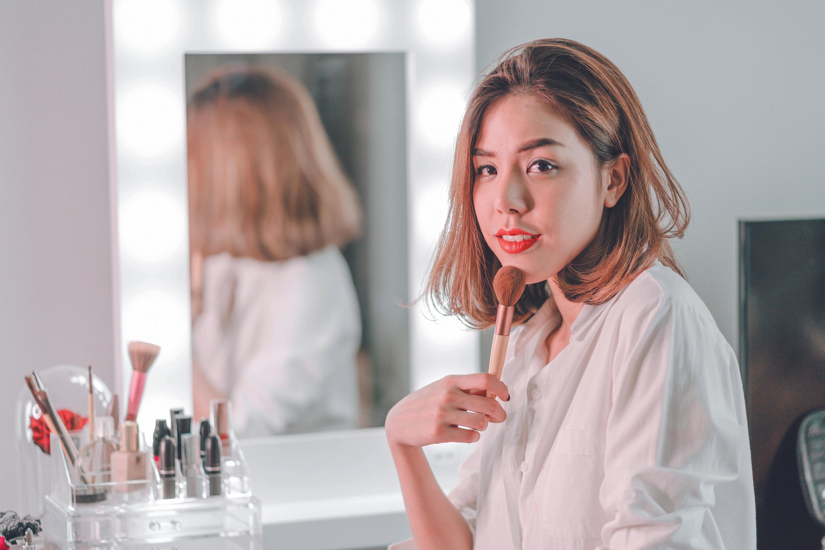 Asian woman applying makeup