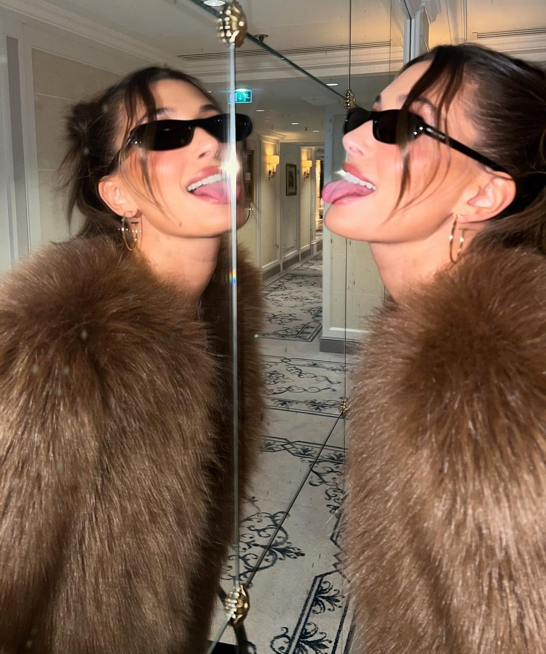 Hailey Bieber wearing sunglasses and fur coat.