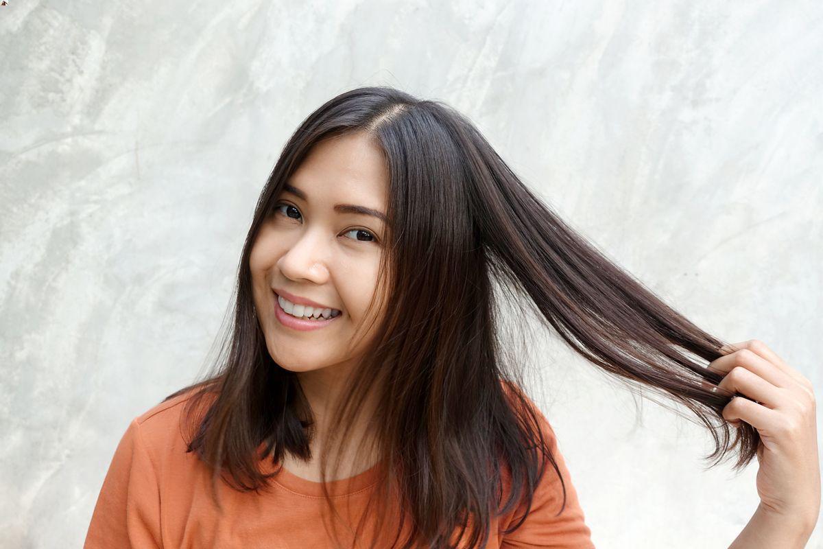 Asian woman pulling her straight hair 