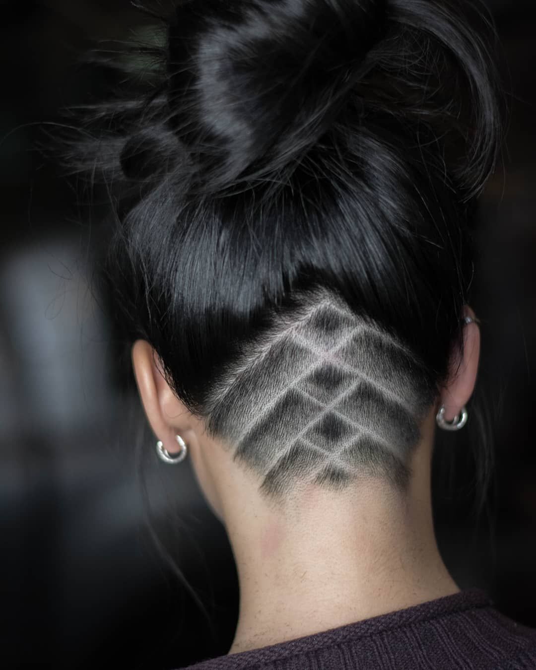 Woman with graphic lines drawn on her undercut at the back of her head.
