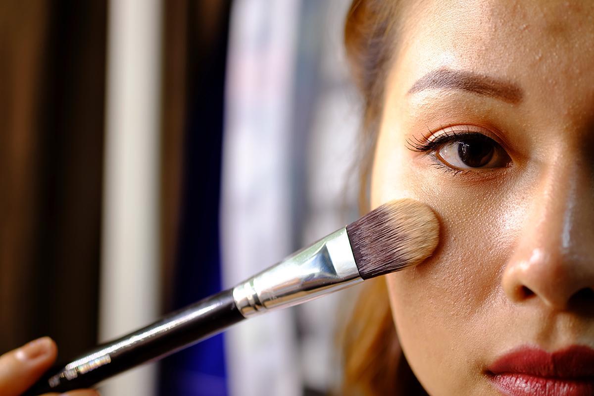 Asian woman applying foundation