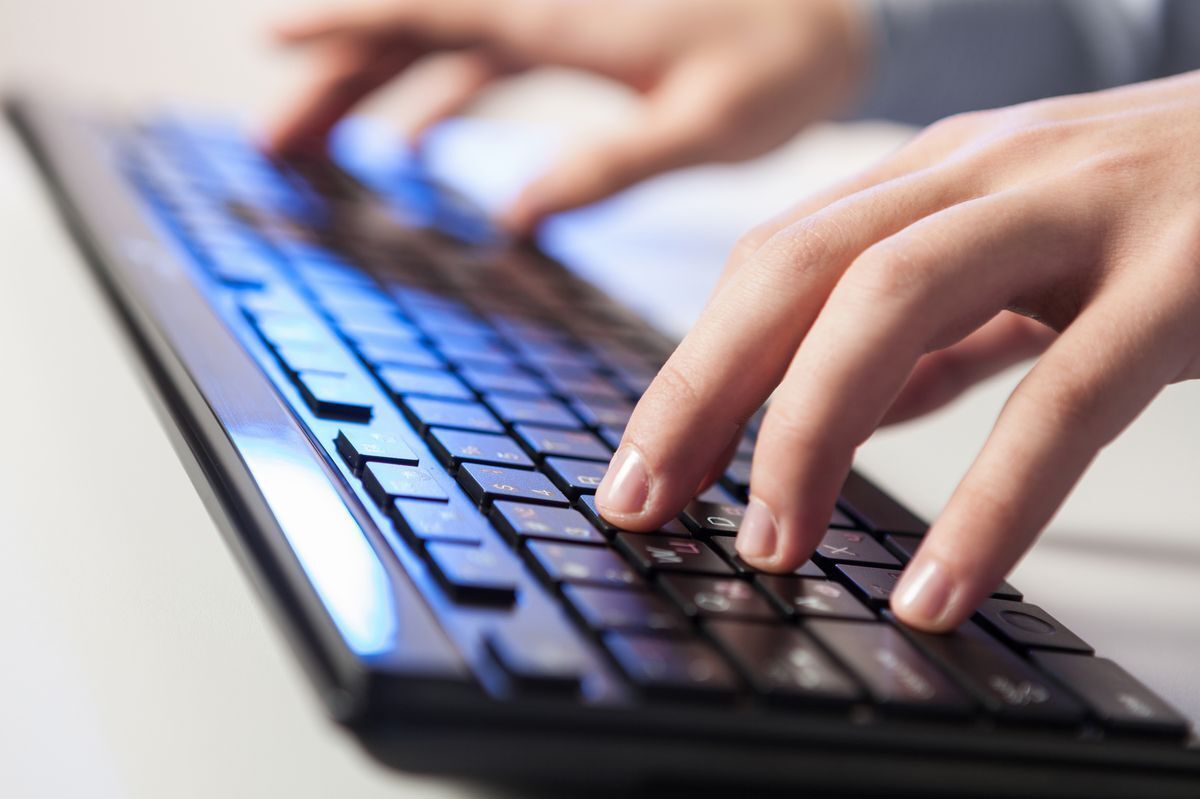 A man types on a wireless keyboard