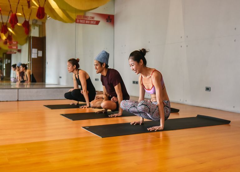 Three people doing yoga together on their individual mats