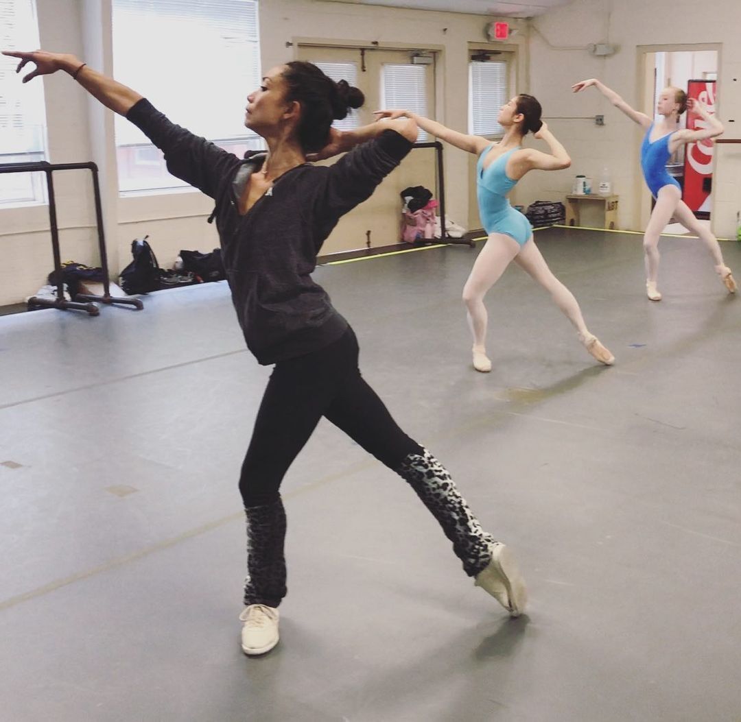 A ballerina doing her ballet pose in the kitchen
