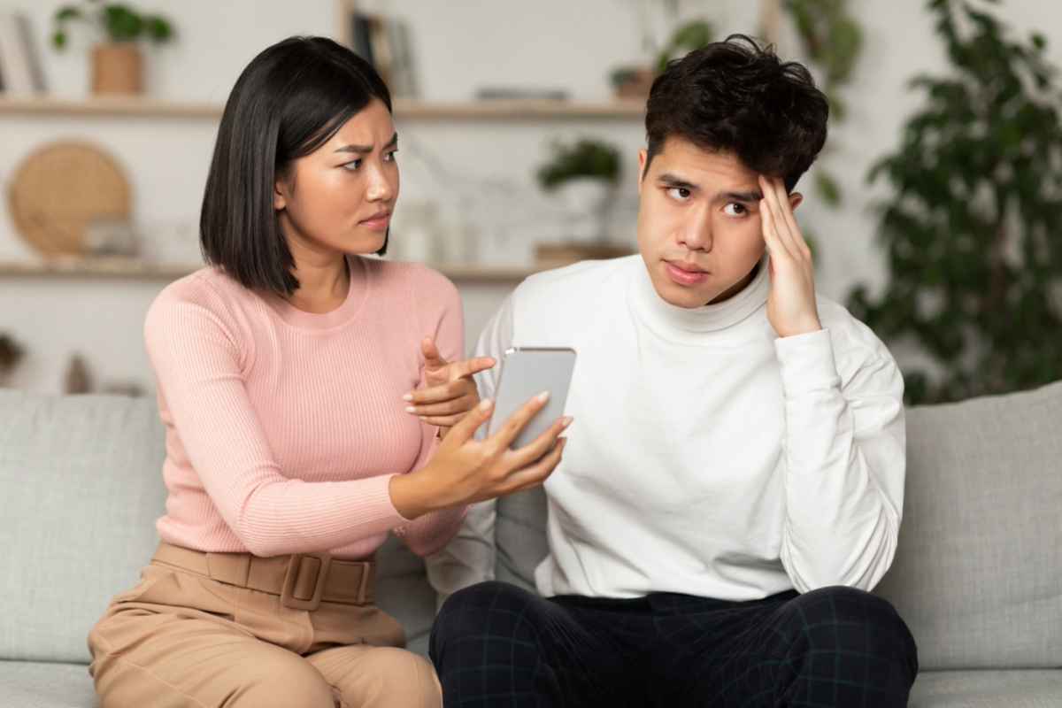 A man and a woman arguing over text messages on a mobile phone.