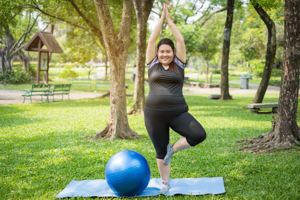 Plus size Asian woman exercising outdoors 
